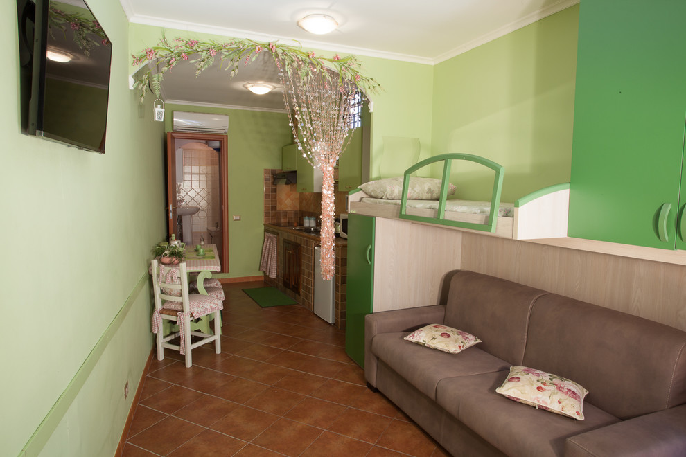 Foto på ett litet lantligt loftrum, med gröna väggar och en väggmonterad TV