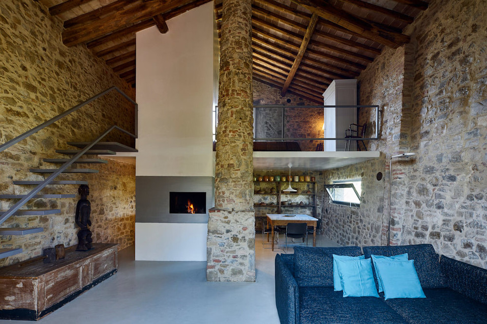 Пример оригинального дизайна: гостиная комната в стиле кантри с горизонтальным камином, фасадом камина из штукатурки и серым полом