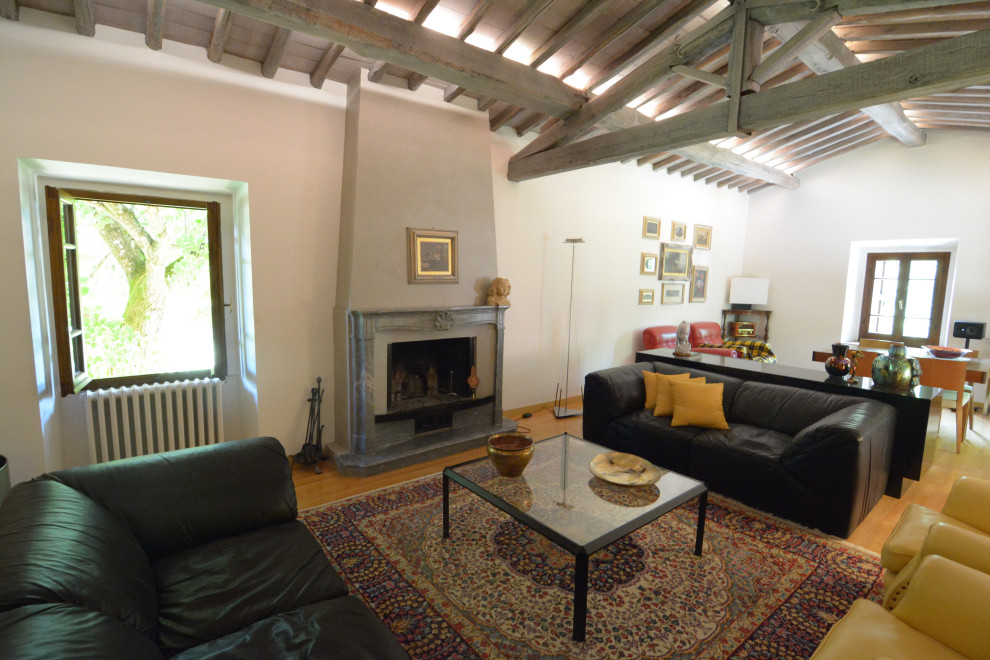 Photo of an expansive rural open plan games room in Florence with a reading nook, beige walls, light hardwood flooring, a standard fireplace, a stone fireplace surround, no tv and yellow floors.