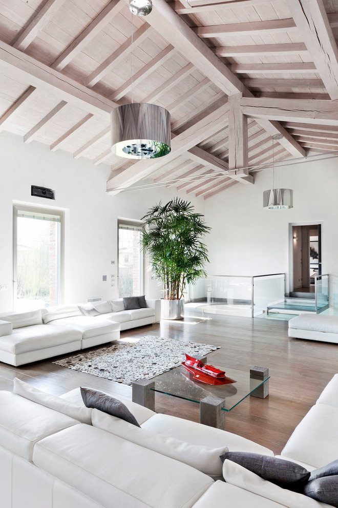 Design ideas for a contemporary open plan living room in Milan with white walls and medium hardwood flooring.