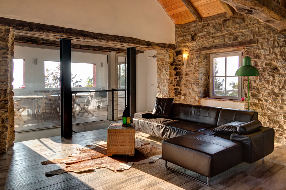 Großes, Offenes Modernes Wohnzimmer mit bunten Wänden, hellem Holzboden und beigem Boden in Turin