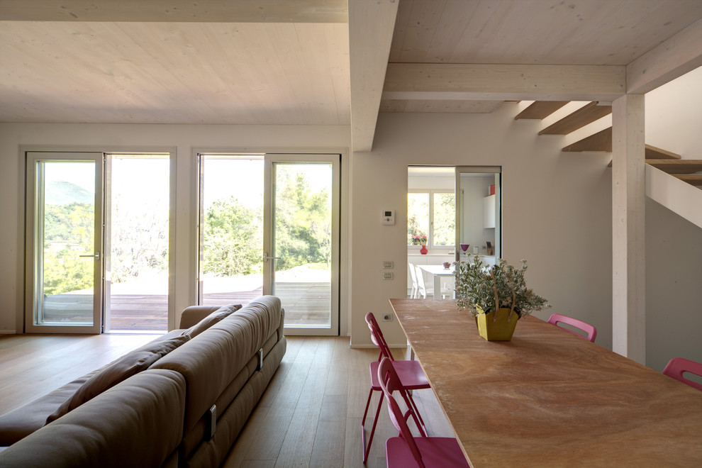 Idées déco pour un grand salon contemporain ouvert avec un mur blanc et un sol en bois brun.