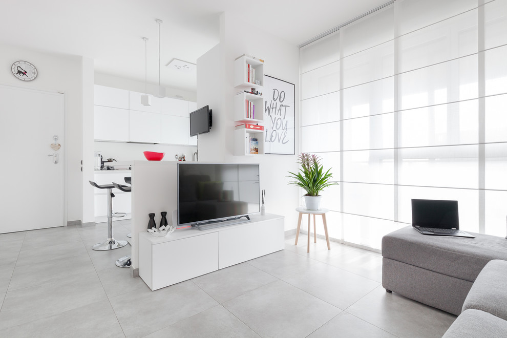 Immagine di un soggiorno design aperto con pareti bianche, nessun camino, TV autoportante e pavimento grigio