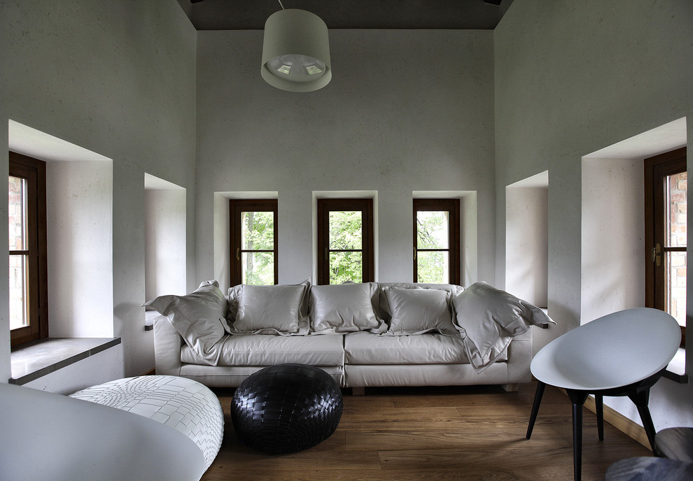 Idee per un piccolo soggiorno moderno chiuso con pareti bianche, pavimento in legno massello medio e pavimento marrone
