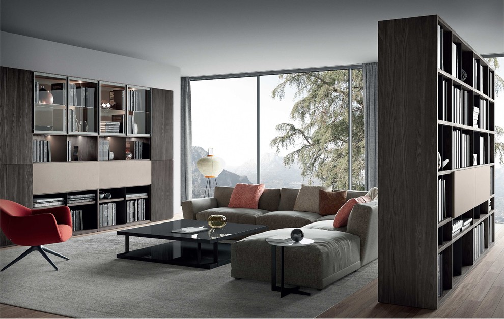 Esempio di un grande soggiorno moderno stile loft con libreria e parquet chiaro