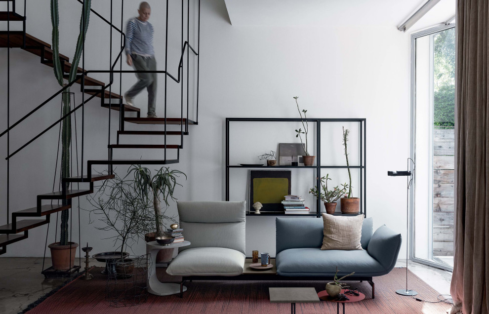 Réalisation d'un salon design de taille moyenne et ouvert avec un mur blanc, sol en béton ciré, un sol gris et un escalier.