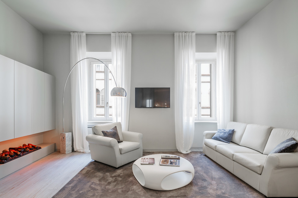 Idéer för ett modernt separat vardagsrum, med en bred öppen spis, ett finrum, grå väggar, ljust trägolv, en väggmonterad TV och beiget golv