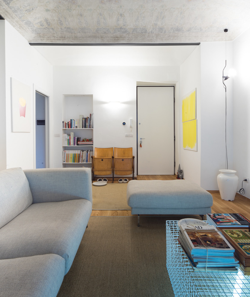 Cette image montre une salle de séjour design de taille moyenne et fermée avec un mur blanc et parquet clair.