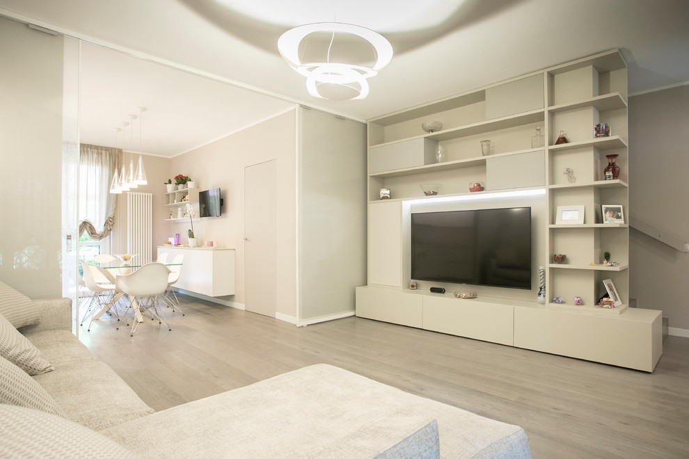 This is an example of a large modern open plan living room in Milan with beige walls, light hardwood flooring, a wall mounted tv and grey floors.