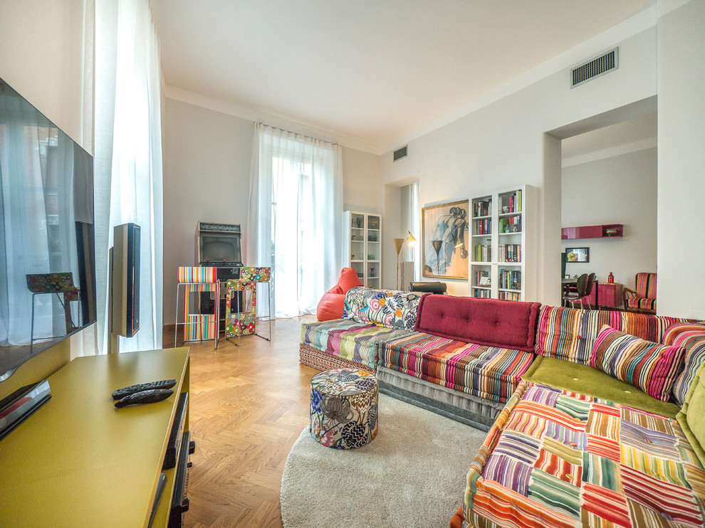 Offenes, Mittelgroßes Stilmix Wohnzimmer mit grauer Wandfarbe, hellem Holzboden, Multimediawand und braunem Boden in Mailand