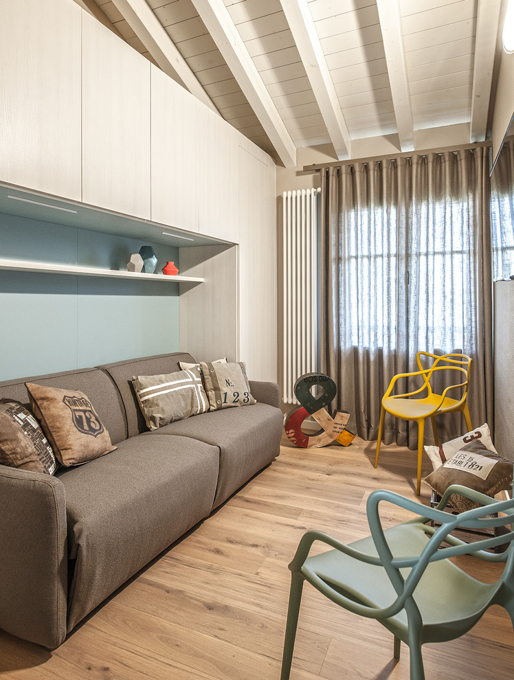Abgetrenntes Modernes Wohnzimmer mit blauer Wandfarbe, hellem Holzboden und TV-Wand in Mailand