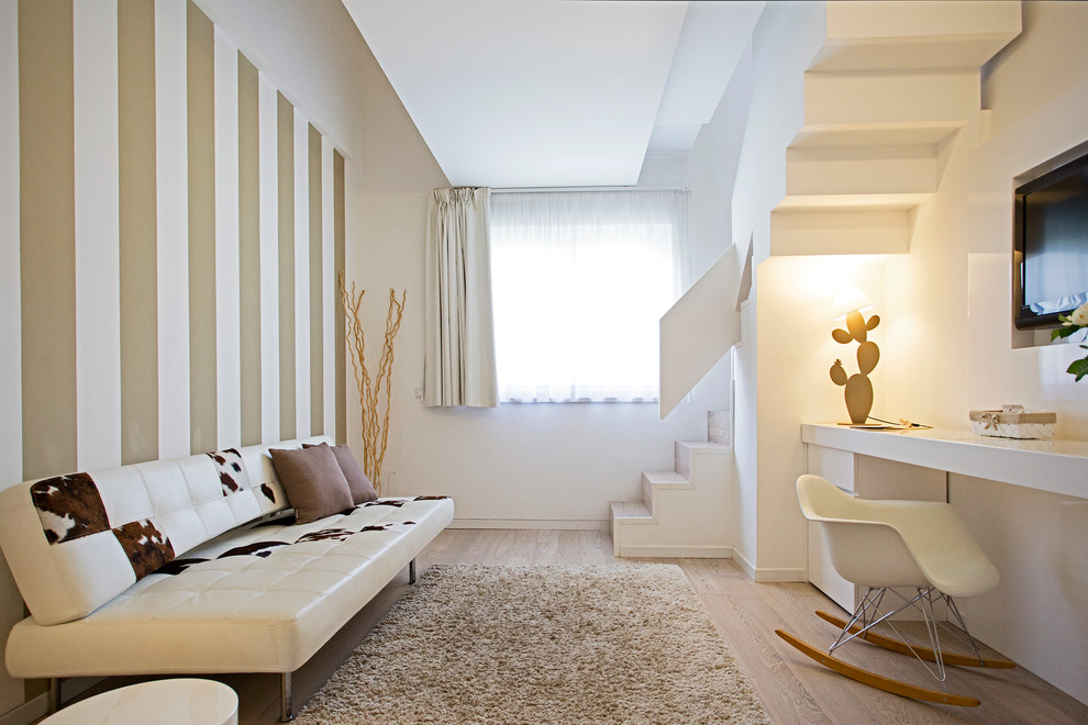 Пример оригинального дизайна: открытая гостиная комната в современном стиле с разноцветными стенами, светлым паркетным полом и телевизором на стене без камина