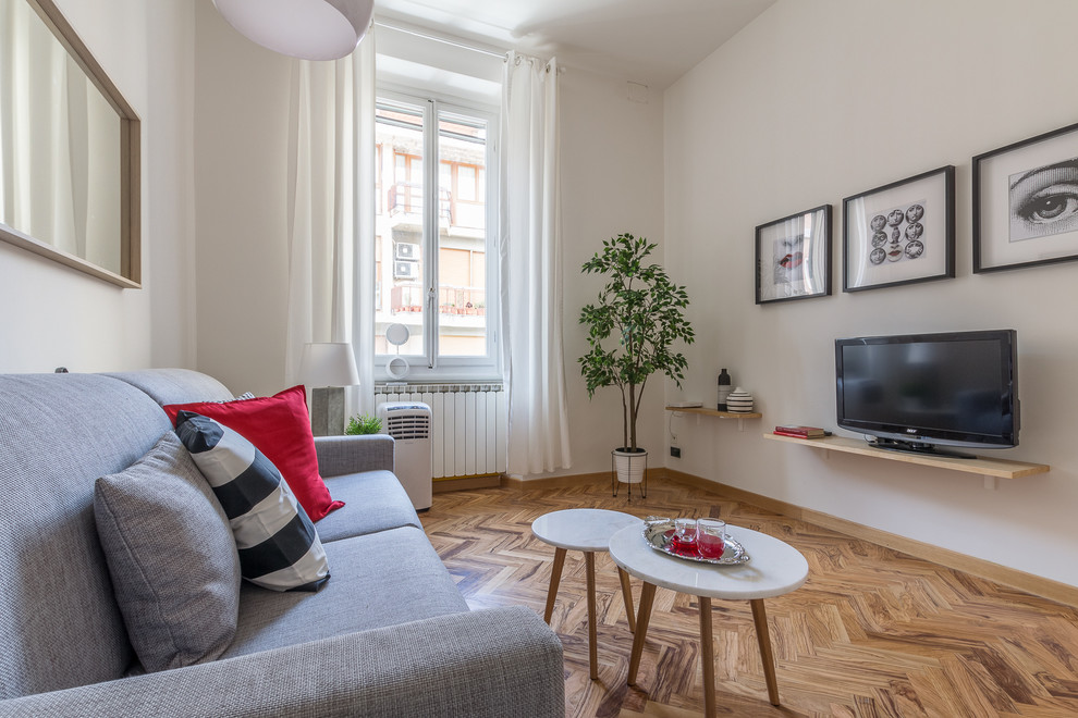 Immagine di un soggiorno design con pareti bianche, pavimento in legno massello medio, TV autoportante e pavimento marrone