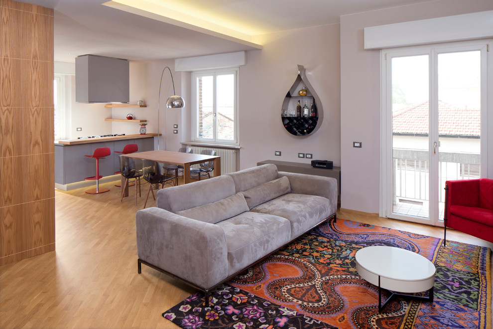 Modelo de salón para visitas abierto contemporáneo sin chimenea con paredes blancas y suelo de madera clara