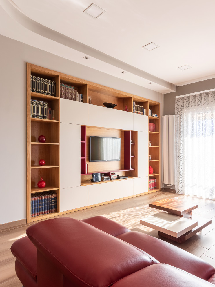 Foto di un ampio soggiorno contemporaneo aperto con libreria, pareti bianche, pavimento in gres porcellanato e TV a parete