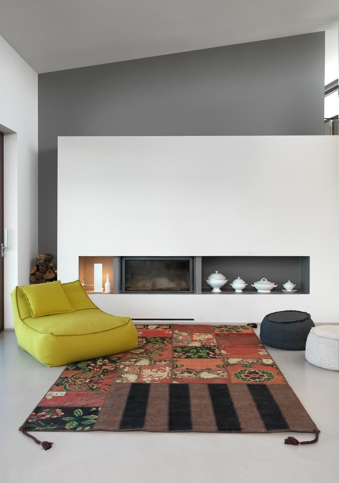Réalisation d'une salle de séjour design ouverte et de taille moyenne avec un mur gris, une cheminée ribbon et un manteau de cheminée en plâtre.