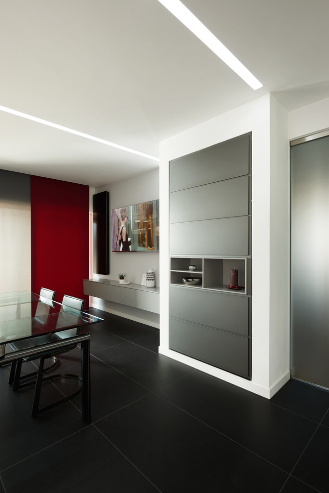 Imagen de salón abierto minimalista grande con paredes blancas, suelo de baldosas de porcelana, televisor colgado en la pared y suelo negro