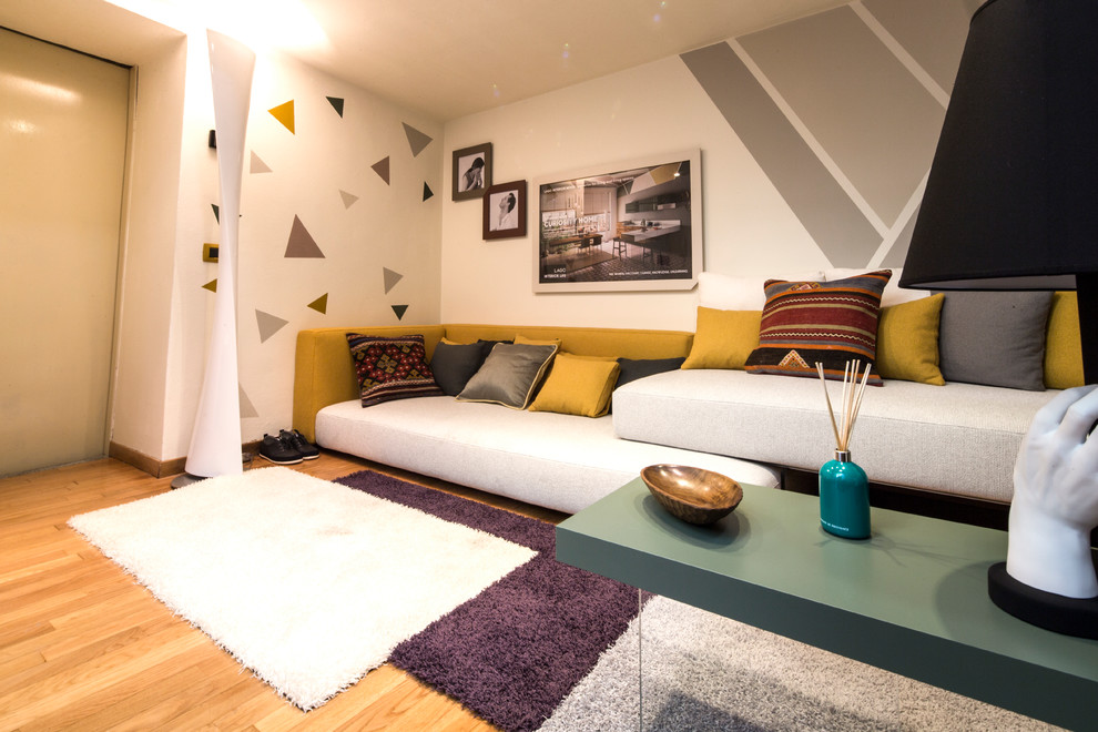 Imagen de sala de estar cerrada actual con suelo de madera clara y paredes blancas
