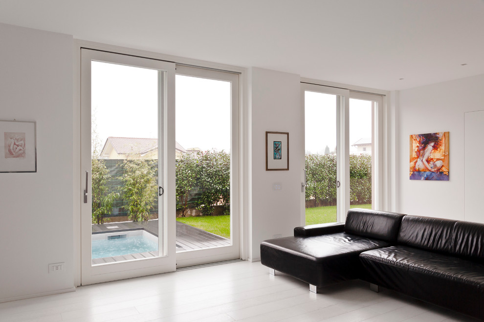 Cette image montre un salon minimaliste avec un mur blanc et parquet clair.