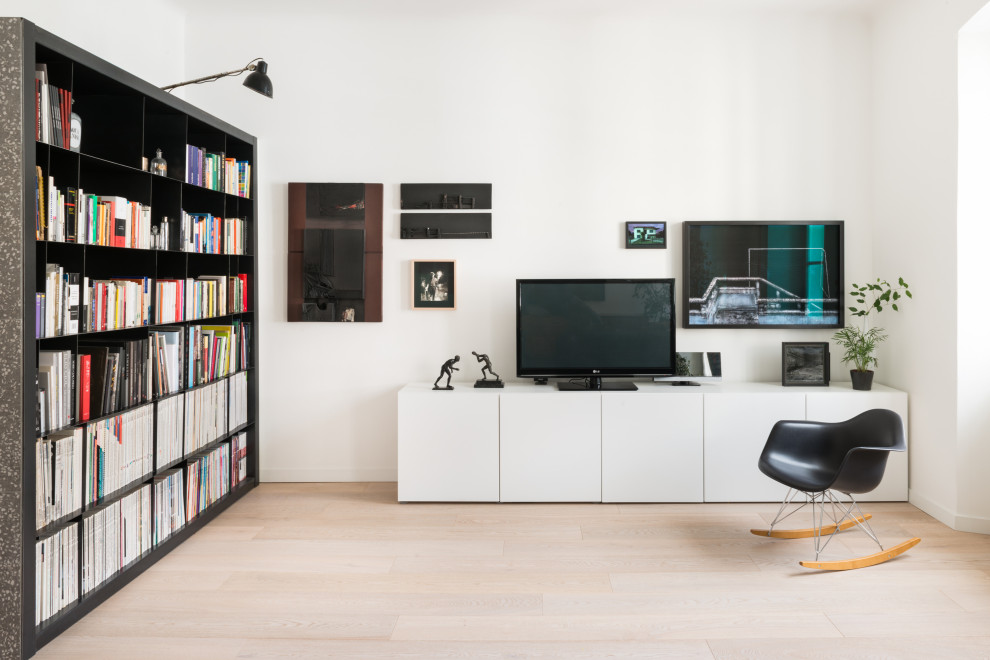 Esempio di un soggiorno design con libreria, pareti bianche, parquet chiaro, TV autoportante e pavimento beige