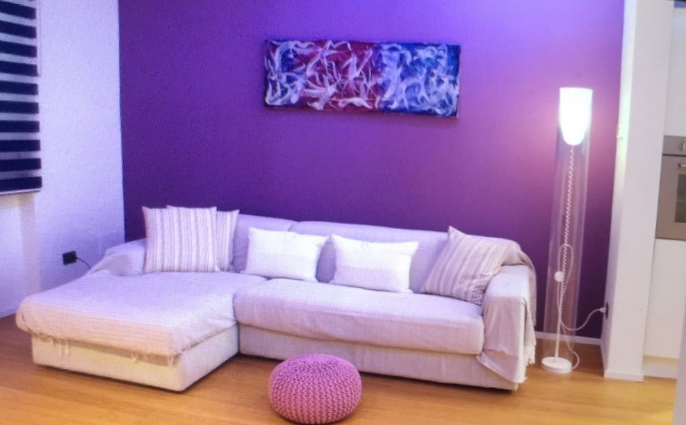 Cette image montre un petit salon design ouvert avec un mur violet, parquet en bambou et un téléviseur encastré.