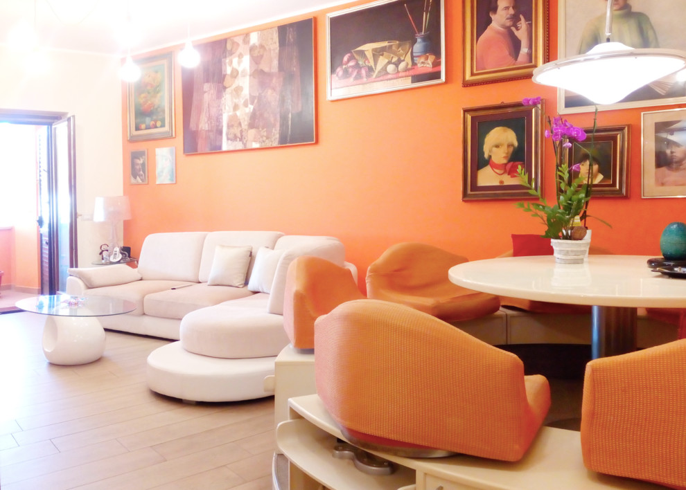 Esempio di un grande soggiorno boho chic aperto con pareti arancioni, pavimento in gres porcellanato, nessun camino, TV a parete e pavimento beige