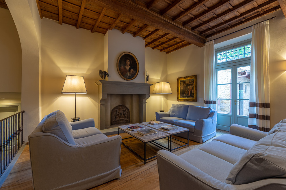 Idee per un soggiorno classico aperto con camino classico, pavimento marrone, pareti beige e pavimento in legno massello medio