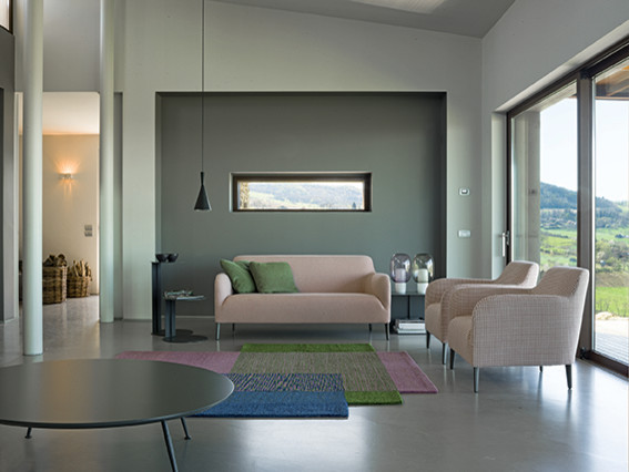 На фото: открытая гостиная комната среднего размера в стиле ретро с серыми стенами, бетонным полом и серым полом с
