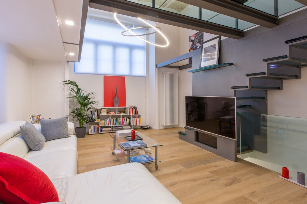 Foto di un soggiorno design aperto con pareti grigie, pavimento in legno massello medio, TV a parete e pavimento marrone