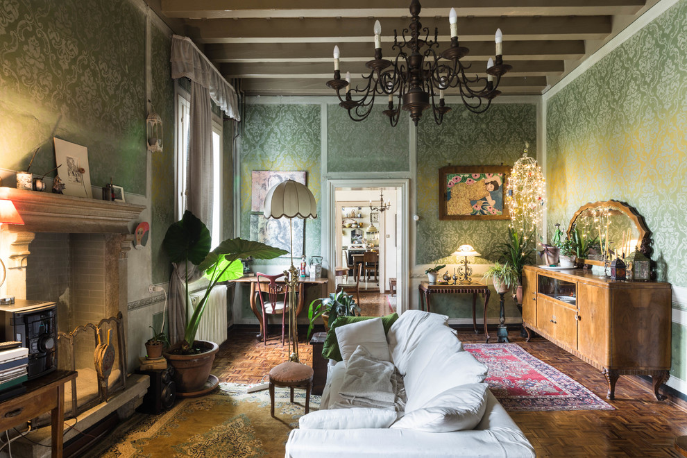 Immagine di un soggiorno boho chic chiuso con pareti verdi, parquet scuro, camino classico e pavimento marrone