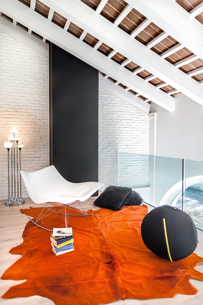 Esempio di un soggiorno bohémian stile loft con pareti bianche, parquet chiaro, camino classico, cornice del camino in metallo, sala formale e tappeto