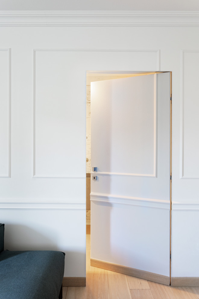 Ejemplo de sala de estar abierta ecléctica pequeña con paredes blancas, suelo de madera clara y televisor independiente