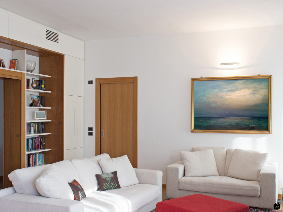 На фото: большая открытая гостиная комната в стиле модернизм с с книжными шкафами и полками, белыми стенами, светлым паркетным полом, стандартным камином, фасадом камина из камня и коричневым полом с