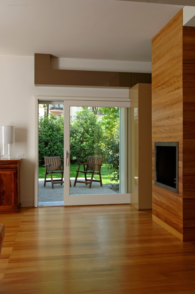 Example of a mid-sized trendy open concept medium tone wood floor and brown floor living room design in Venice with white walls, a two-sided fireplace and a wood fireplace surround