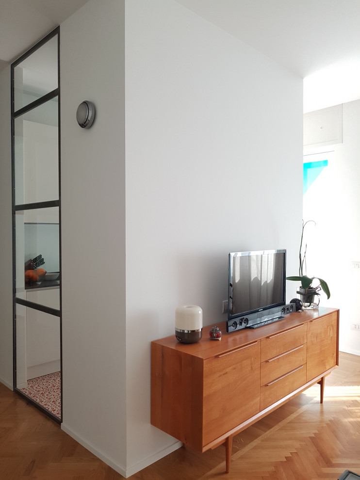 Exempel på ett mellanstort modernt allrum med öppen planlösning, med vita väggar, ljust trägolv och en fristående TV