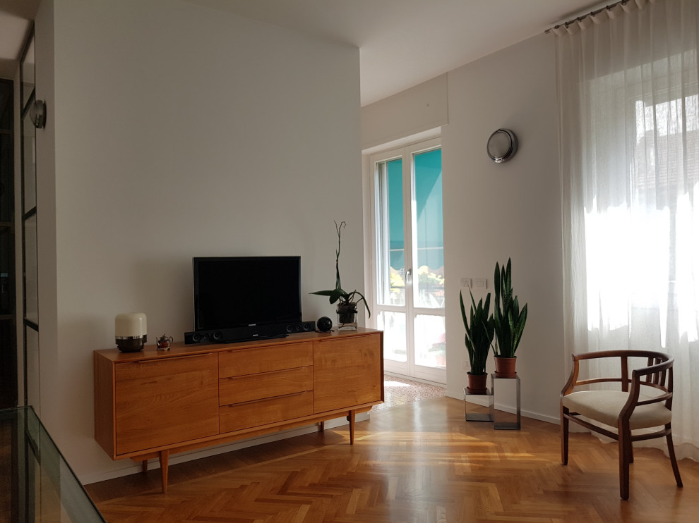 На фото: открытая гостиная комната среднего размера в современном стиле с белыми стенами, светлым паркетным полом и отдельно стоящим телевизором