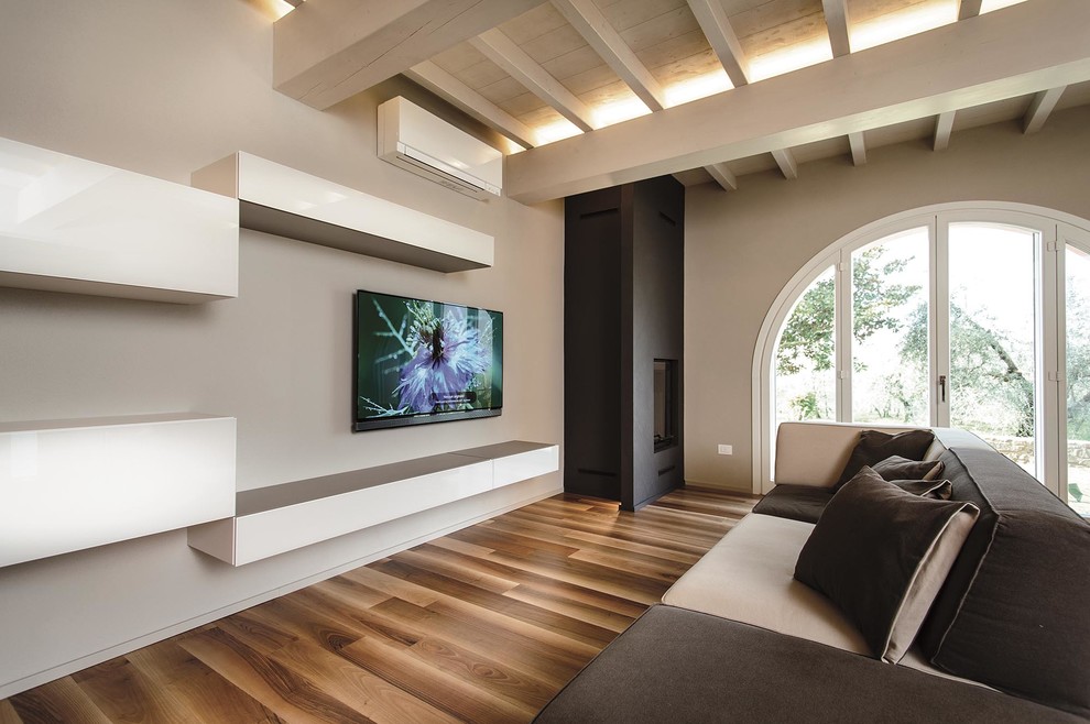 Modelo de salón con barra de bar abierto contemporáneo grande con paredes beige, suelo de madera en tonos medios, chimenea lineal, marco de chimenea de yeso y televisor colgado en la pared