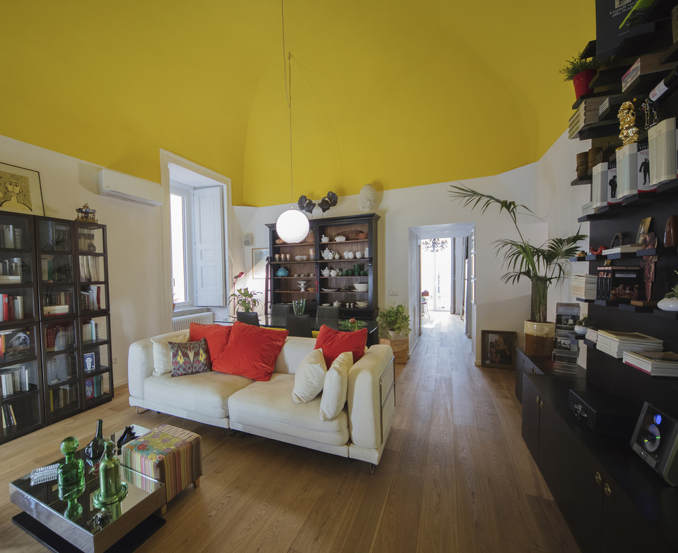 Esempio di un soggiorno contemporaneo di medie dimensioni e chiuso con pareti gialle, parquet chiaro e pavimento marrone