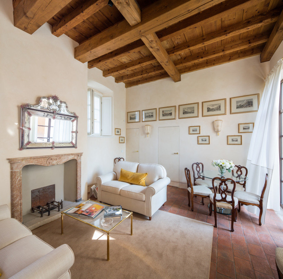 Источник вдохновения для домашнего уюта: изолированная гостиная комната среднего размера в средиземноморском стиле с белыми стенами, кирпичным полом, стандартным камином и фасадом камина из камня