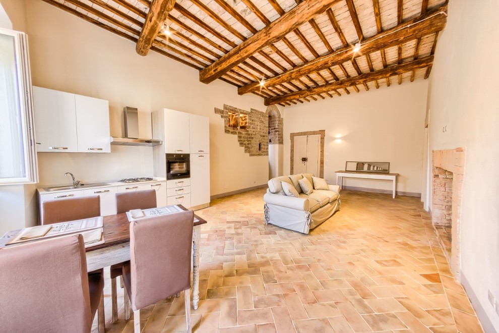 Foto di un soggiorno mediterraneo di medie dimensioni e aperto con pavimento in terracotta, camino classico e cornice del camino in mattoni