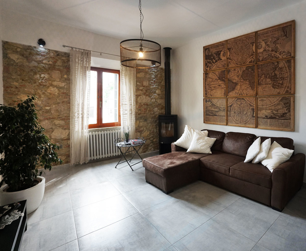 Cette image montre une grande salle de séjour mansardée ou avec mezzanine urbaine avec un mur blanc, un sol en carrelage de porcelaine, une cheminée d'angle, un manteau de cheminée en métal, un téléviseur d'angle et un sol gris.