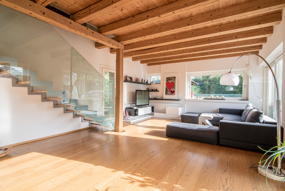 Foto di un soggiorno design aperto con pareti bianche, pavimento in legno massello medio, TV autoportante e pavimento beige