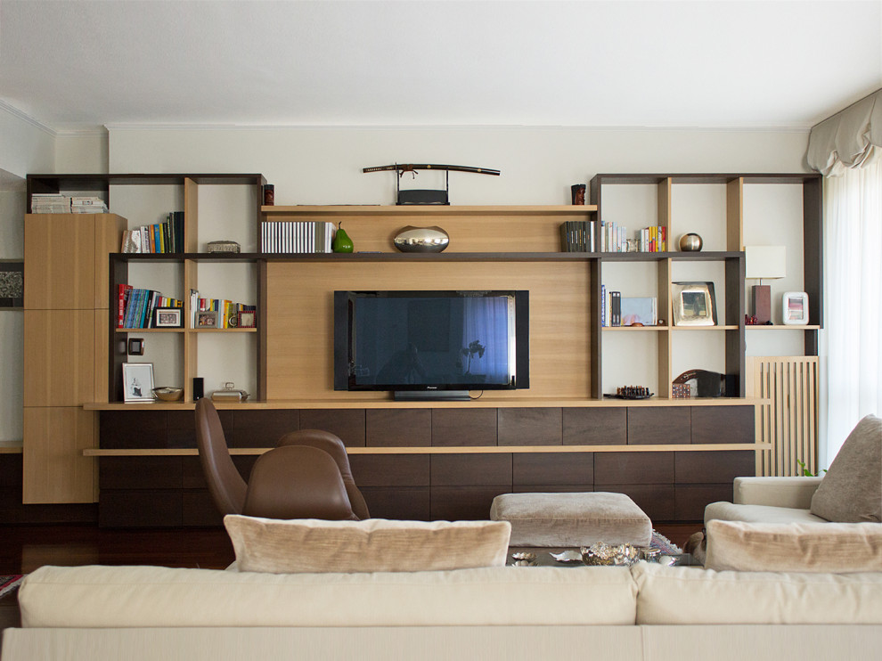 Large elegant open concept dark wood floor and brown floor family room library photo in Milan with beige walls and a media wall
