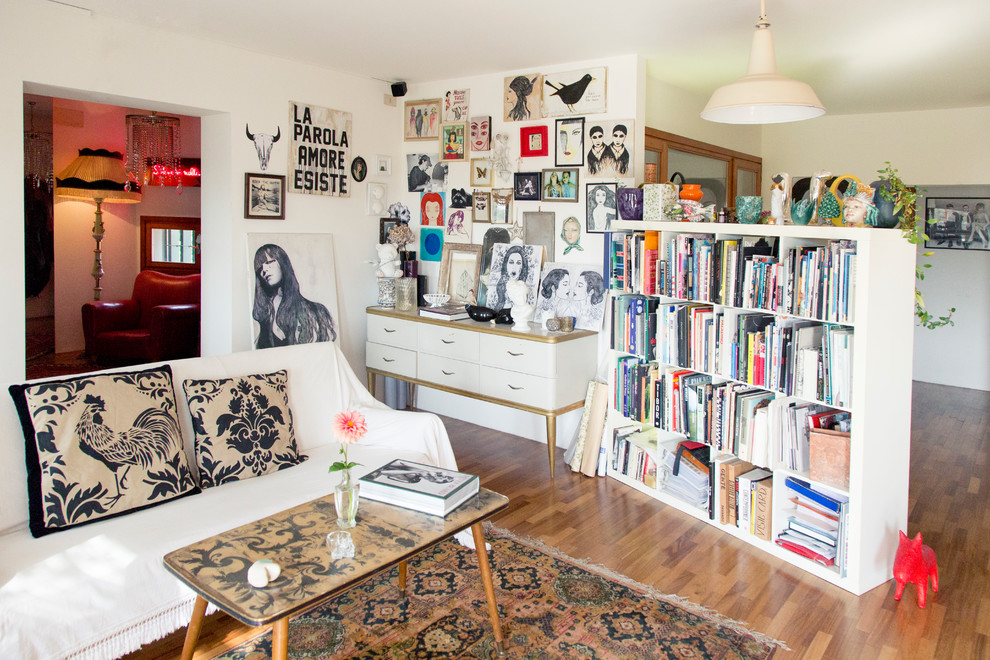 Foto di un soggiorno bohémian di medie dimensioni con libreria, pareti bianche e pavimento in legno massello medio