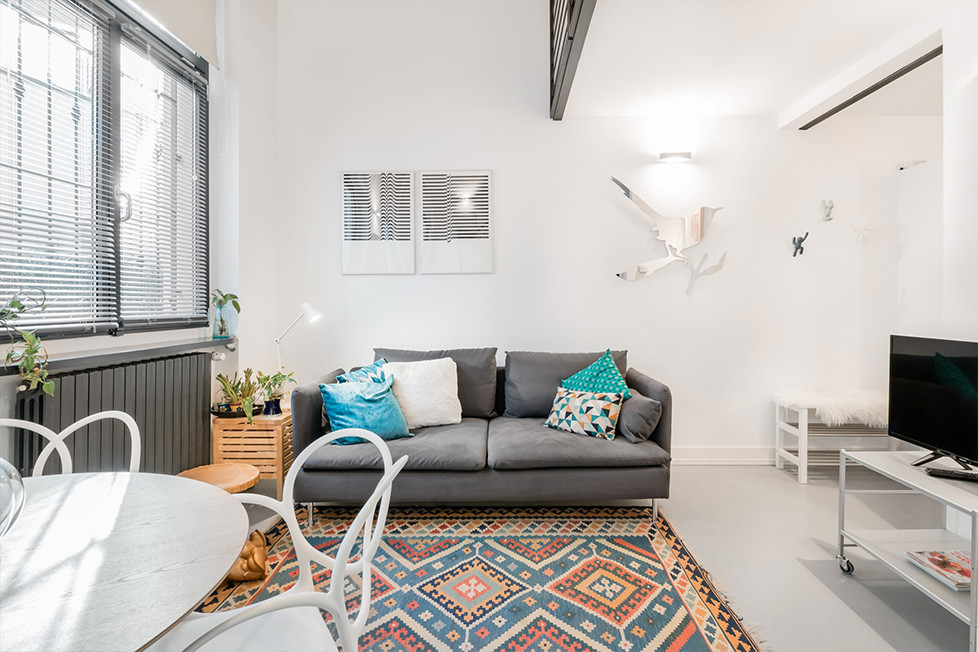 Foto di un piccolo soggiorno design aperto con pareti bianche e pavimento grigio