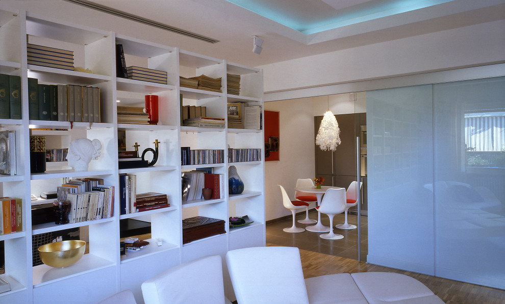 Ispirazione per un ampio soggiorno design chiuso con libreria, pareti bianche, parquet chiaro, TV a parete, pavimento beige e soffitto ribassato