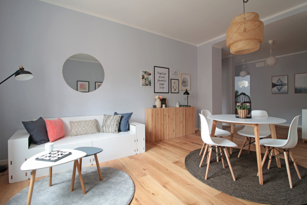 На фото: открытая гостиная комната среднего размера в скандинавском стиле с серыми стенами и светлым паркетным полом