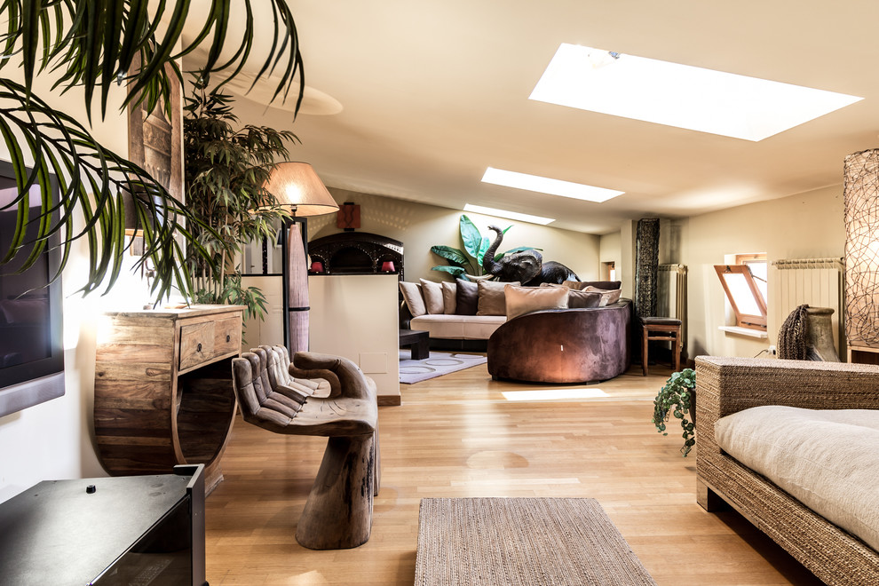 Diseño de salón para visitas abierto tropical grande con paredes beige, suelo de madera en tonos medios, televisor colgado en la pared y suelo marrón