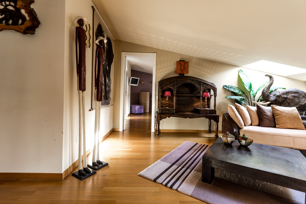 Immagine di un grande soggiorno tropicale aperto con sala formale, pavimento in legno massello medio, pavimento marrone e pareti bianche
