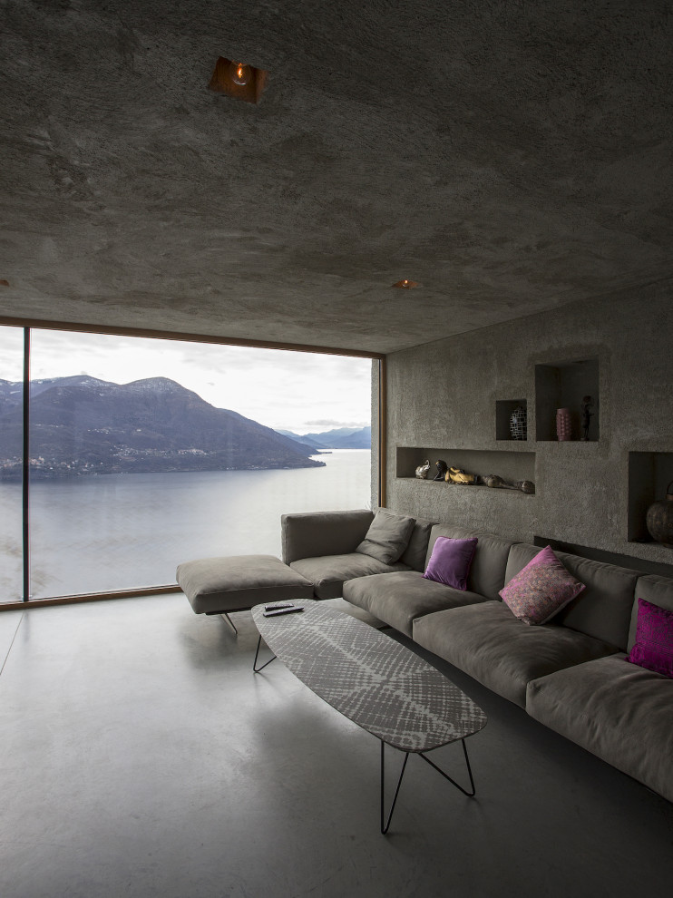 Idées déco pour un salon moderne avec un mur gris, sol en béton ciré et un sol gris.